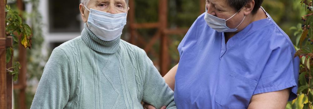 Female Nurse Taking Care Older Woman With Medical Mask